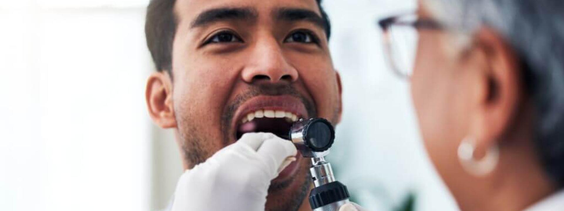 Protecting Your Smile: Essential Facts About Oral Cancer Screenings and Early Detection Dentist performing oral cancer screening on a male patient